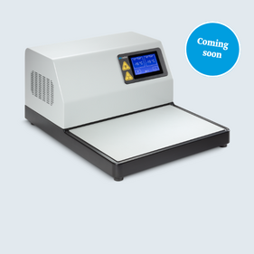 Ein moderner Laborger&auml;t mit einer flachen Arbeitsfl&auml;che und einem Display, das Temperaturdaten anzeigt. Das Ger&auml;t ist &uuml;berwiegend wei&szlig; mit schwarzen Elementen. Ein blauer Sticker weist darauf hin, dass das Produkt bald erh&auml;ltlich ist.